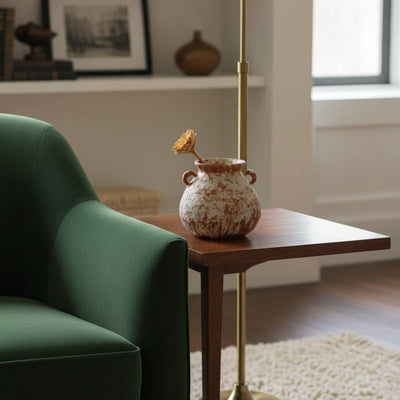 Rustic terracotta patterned vase with handles on wooden side table for warm cozy home interior and elegant decor.