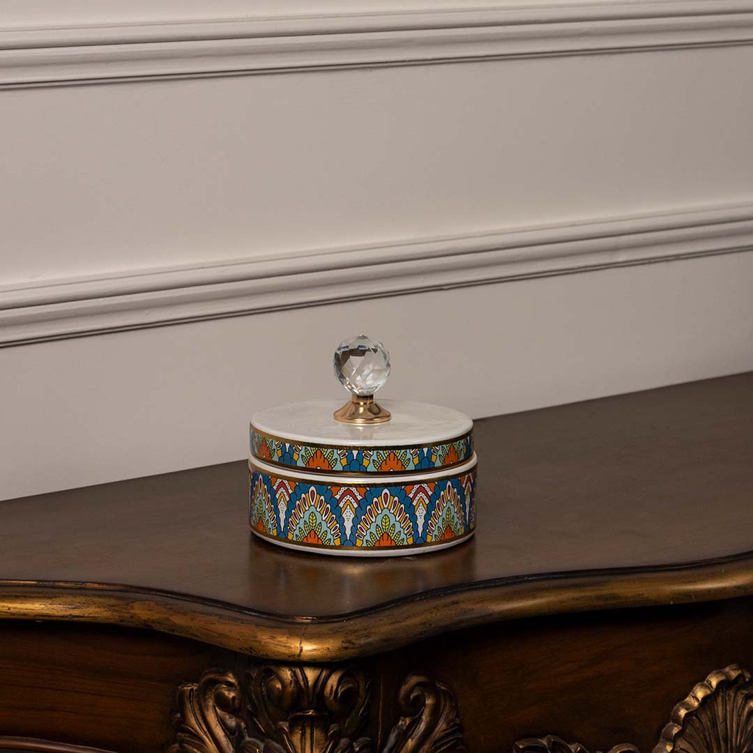 Round ceramic jar with multicolor geometric pattern and crystal knob lid perfect for vibrant home interior styling.