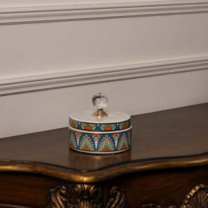 Round ceramic jar with multicolor geometric pattern and crystal knob lid perfect for vibrant home interior styling.