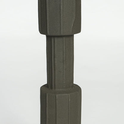 Close view of dark green metal candle holder highlighting faceted cylindrical design and matte textured finish.