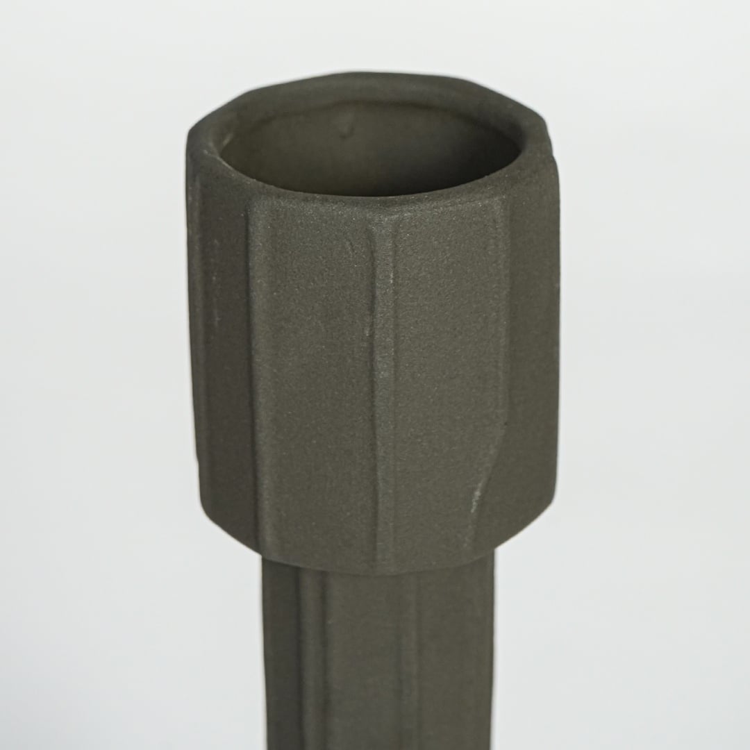 Dark green metal decorative candle holder with faceted cylindrical design isolated on clean white background for modern decor styling.