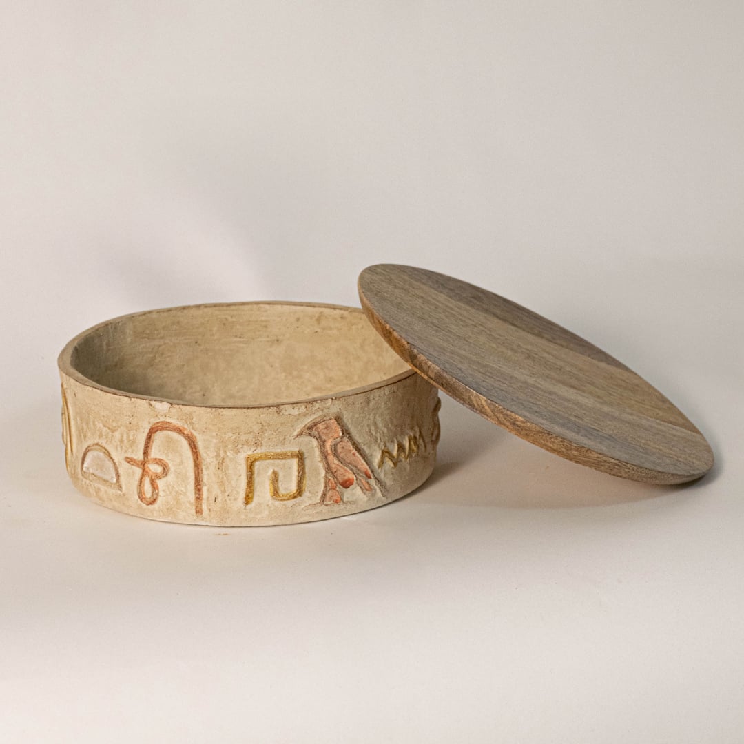 Handcrafted hieroglyph box displayed on white background showing lid detail and textured artisan carving.