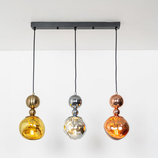 Warm glowing gold silver and copper pendant lights with adjustable wires displayed against a white background for stylish home decor.