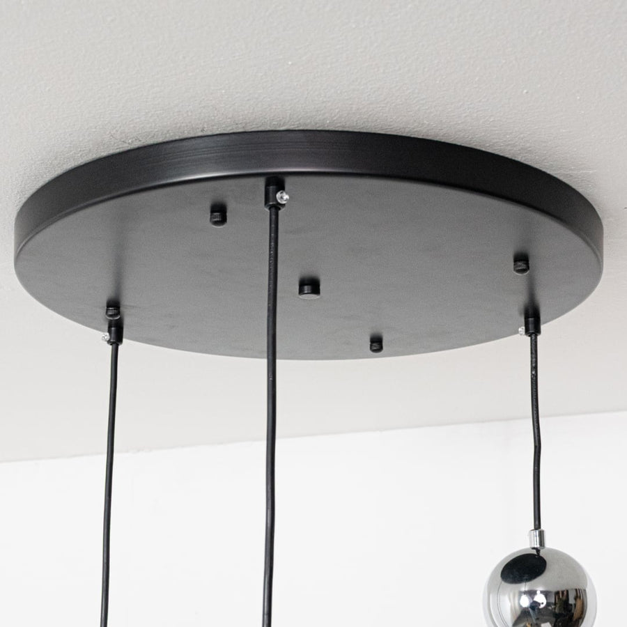 Black metal round ceiling canopy with suspended cords showcasing sleek modern craftsmanship and finish.