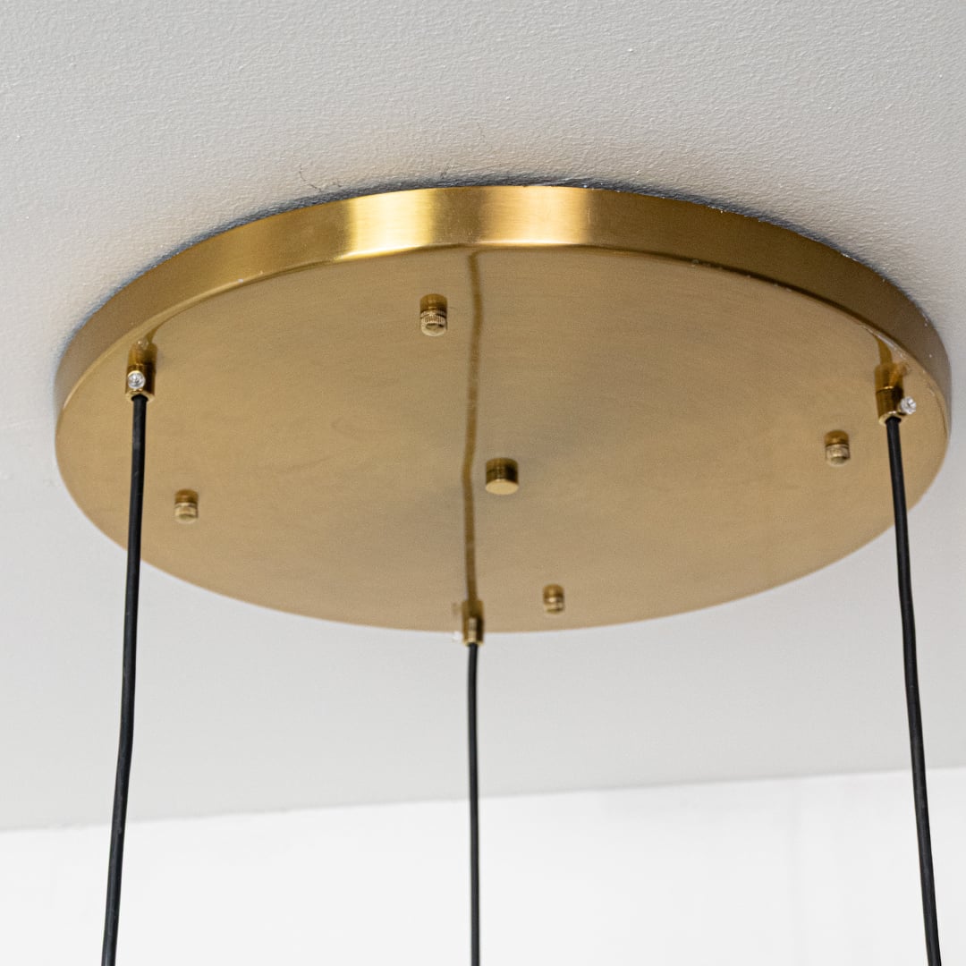 Closeup of gold chrome and copper pendant lights showing smooth reflective surfaces and modern rounded shapes for stylish decor.