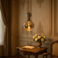 Gold metal pendant light above dining table creating warm luxury ambiance in an elegant dining room setting.