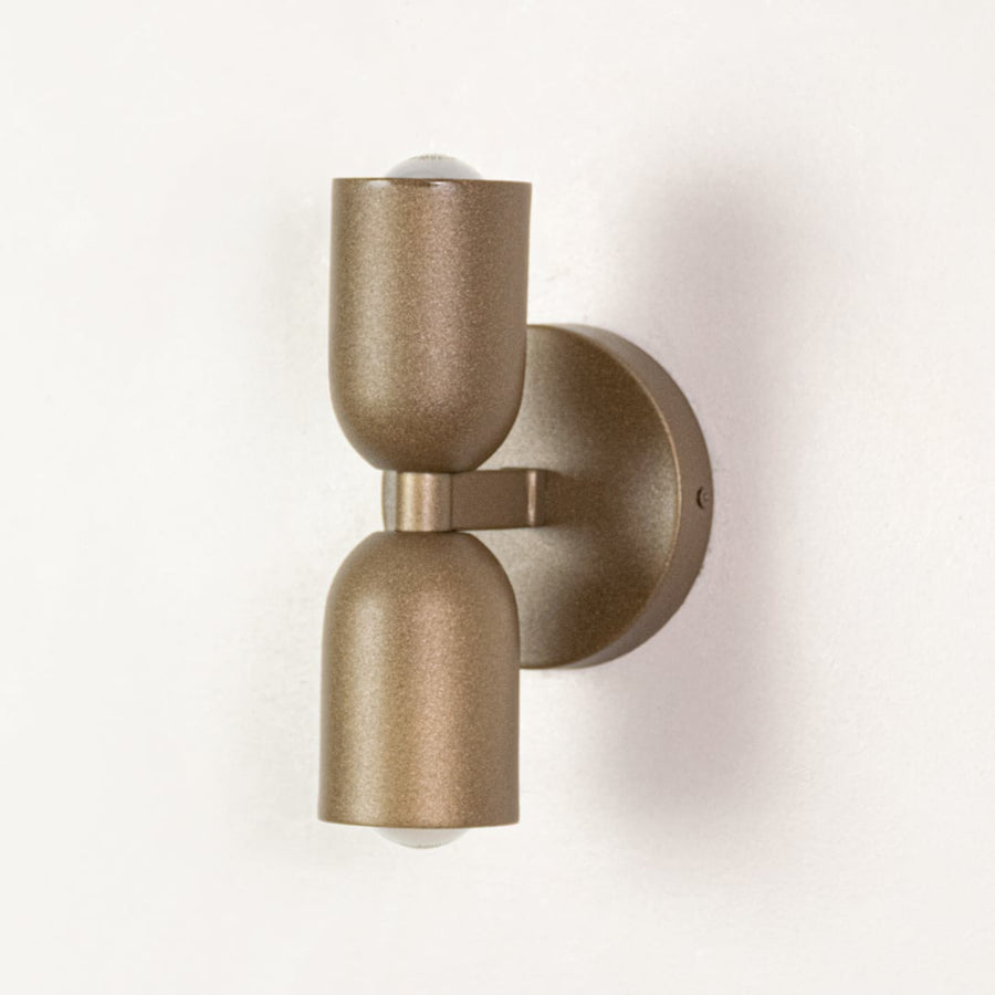 Modern wall light in metal finish with cylindrical form displayed on white background highlighting minimal design for indoor wall placement.