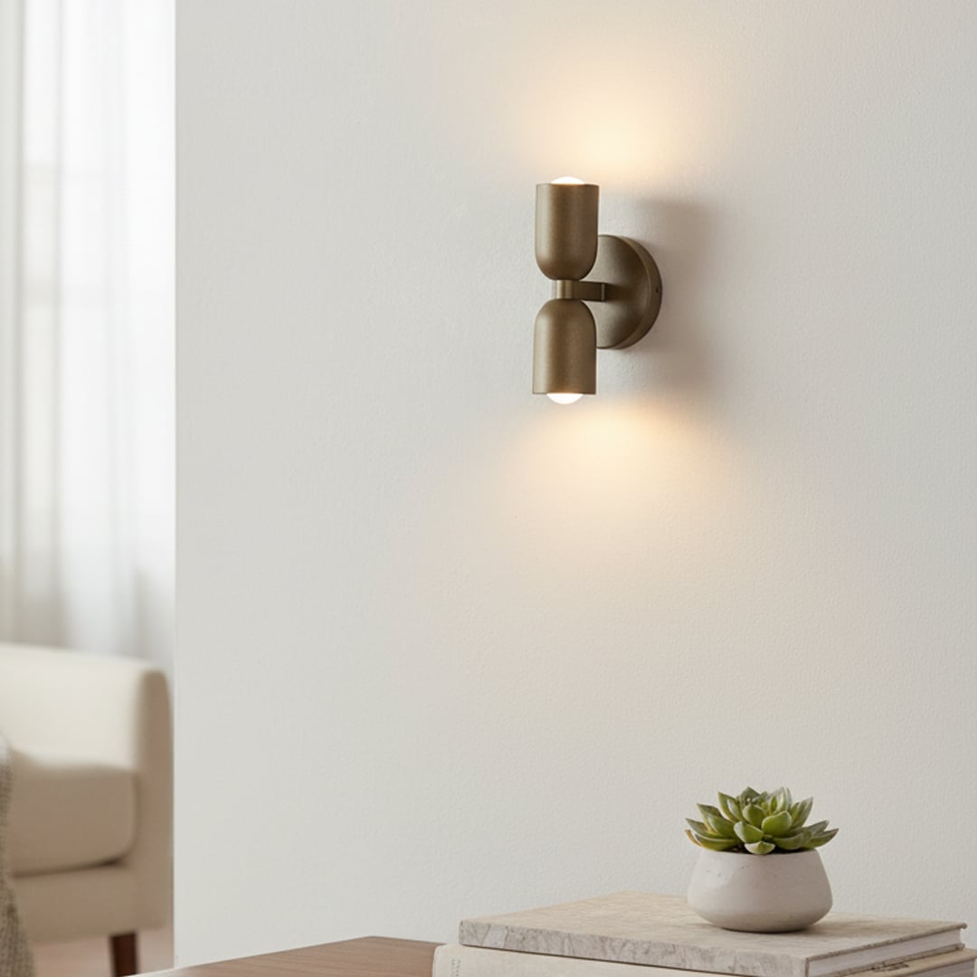 Gold double wall sconce glowing softly beside bed adding warmth and modern elegance to cozy bedroom decor.