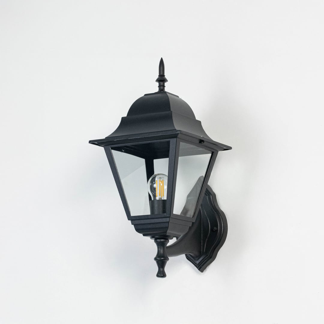 Black outdoor wall light with elegant lantern design and clear glass panels displayed on a white background with bulb turned off.