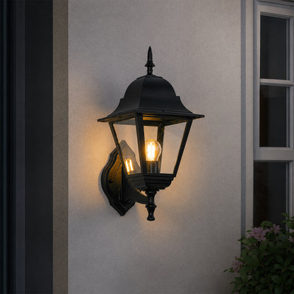 Black metal outdoor lantern wall light lifestyle image with warm glow for elegant exterior entryway decor.