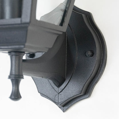 Closeup image of black metal outdoor wall light base with textured finish for durable exterior decor.