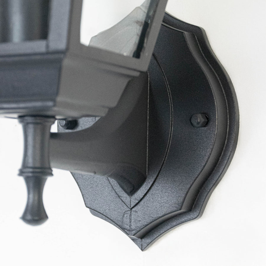 Closeup image of black metal outdoor wall light base with textured finish for durable exterior decor.