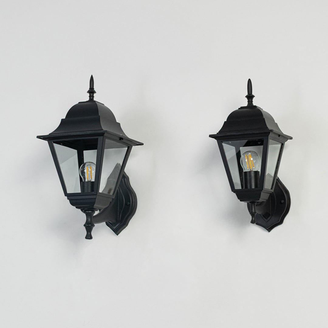 Group of outdoor wall lanterns in black finish displayed off on white background showing detailed glass and metal design.