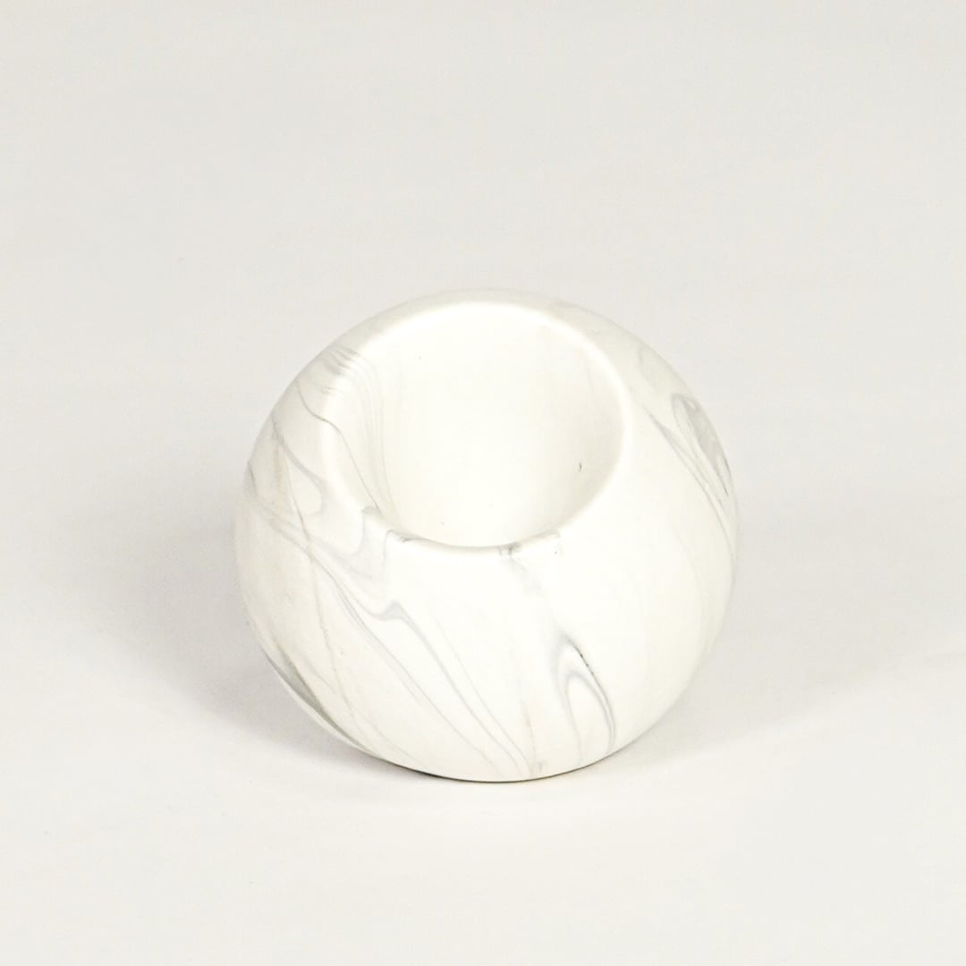 Modern white marble look ceramic vase with spherical body isolated on white background for tabletop styling.