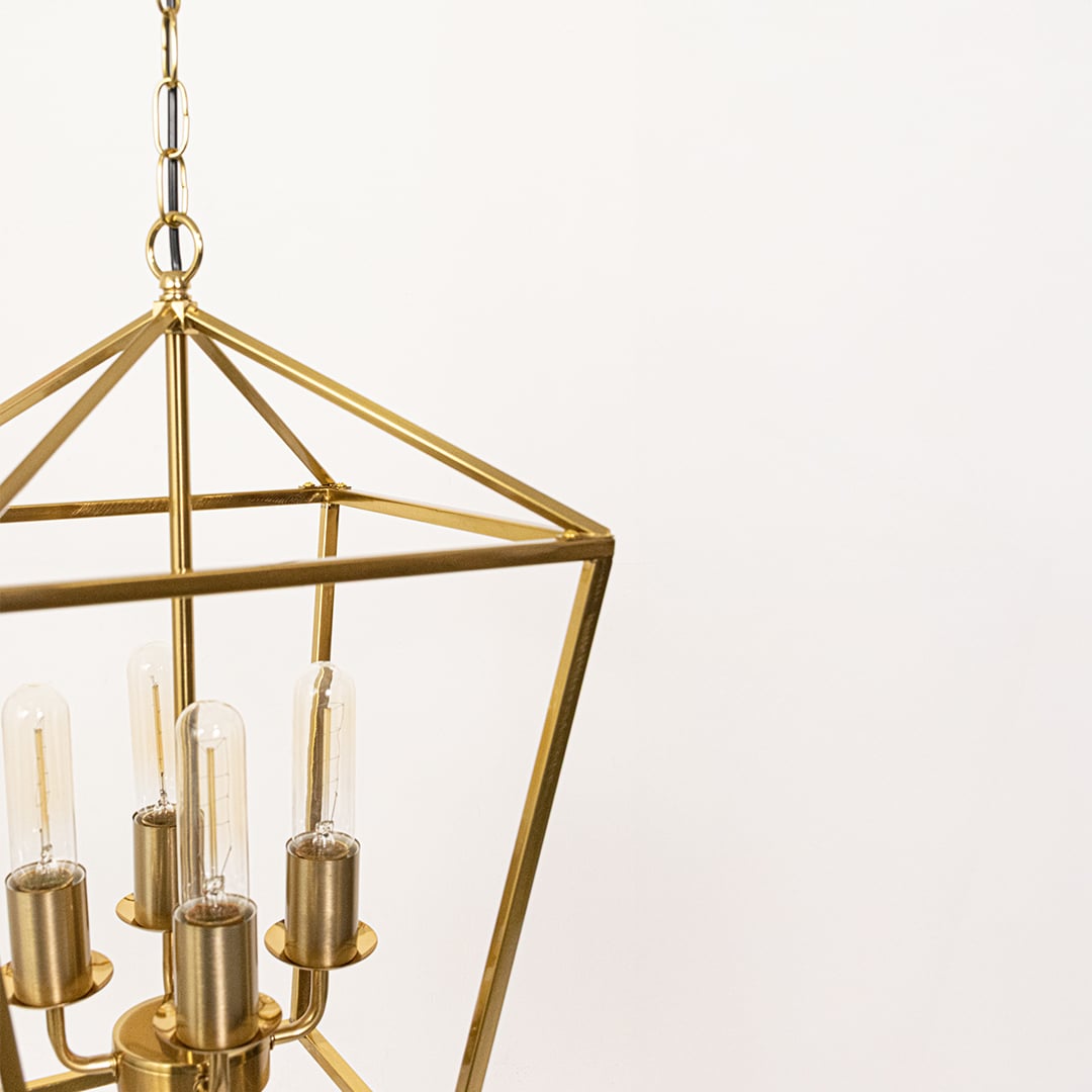 Closeup of gold metal pendant light highlighting the clear bulbs and geometric frame detailing for premium modern interior lighting.