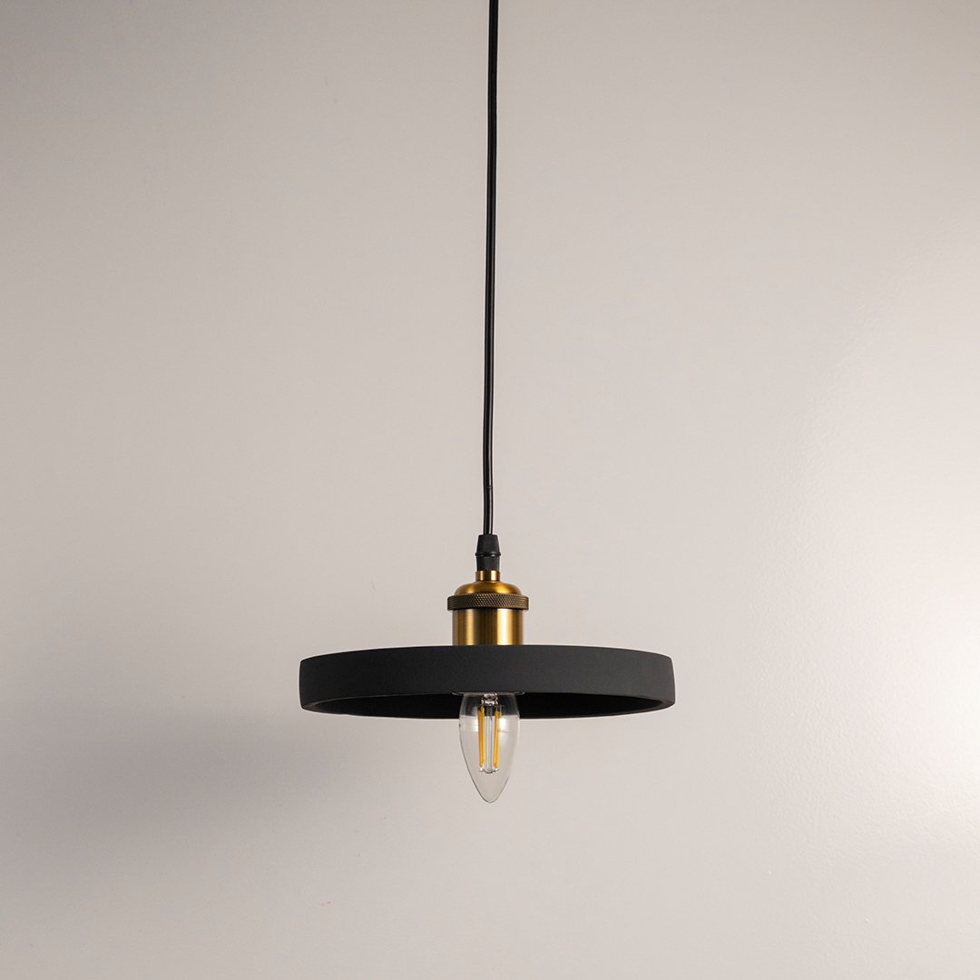 Black metal pendant light with gold accents and flat disc shade crafted for modern living spaces.
