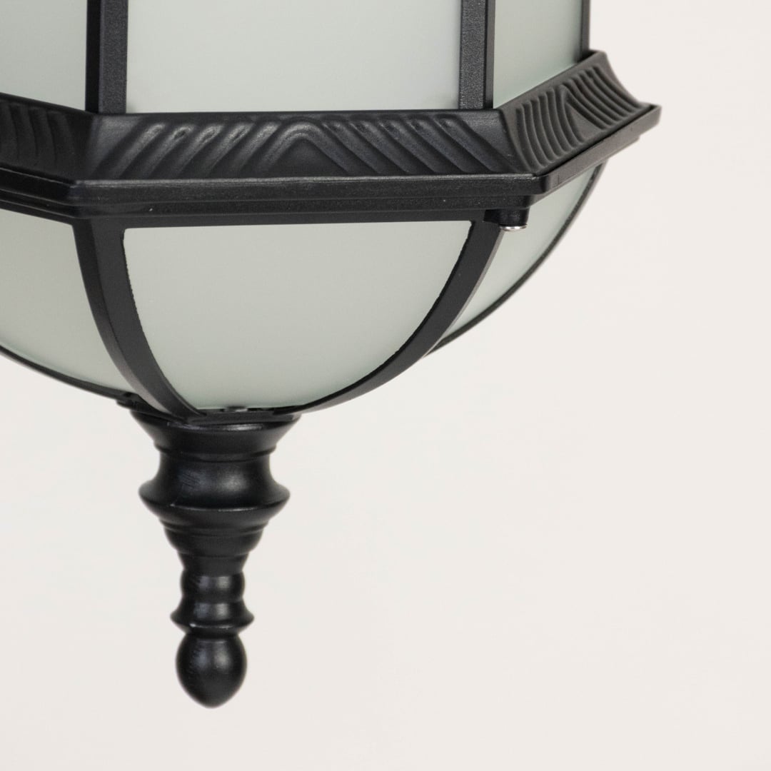 Closeup of outdoor lantern base with black metal frame and frosted glass diffuser highlighting sturdy construction and classic design.