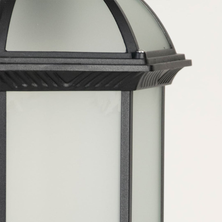 Outdoor wall lantern in black metal with glass panels highlighting classic design and warm illumination for exterior home decor.