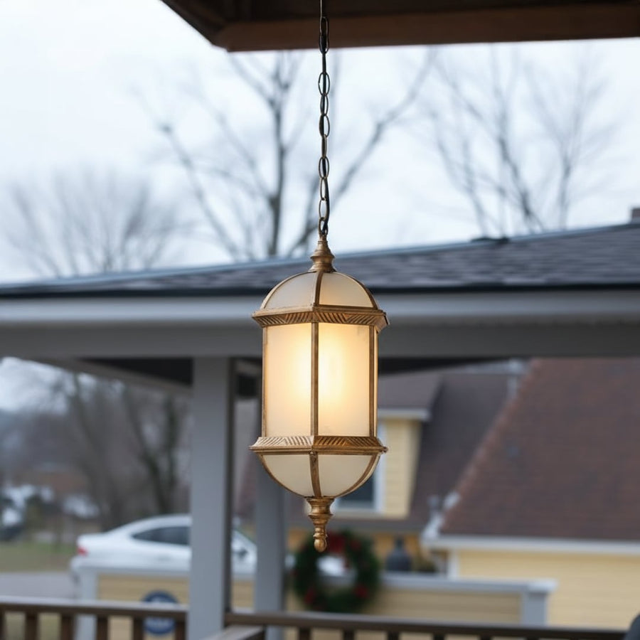 Vintage brass hanging lantern light with frosted glass creating cozy balcony evening ambiance.