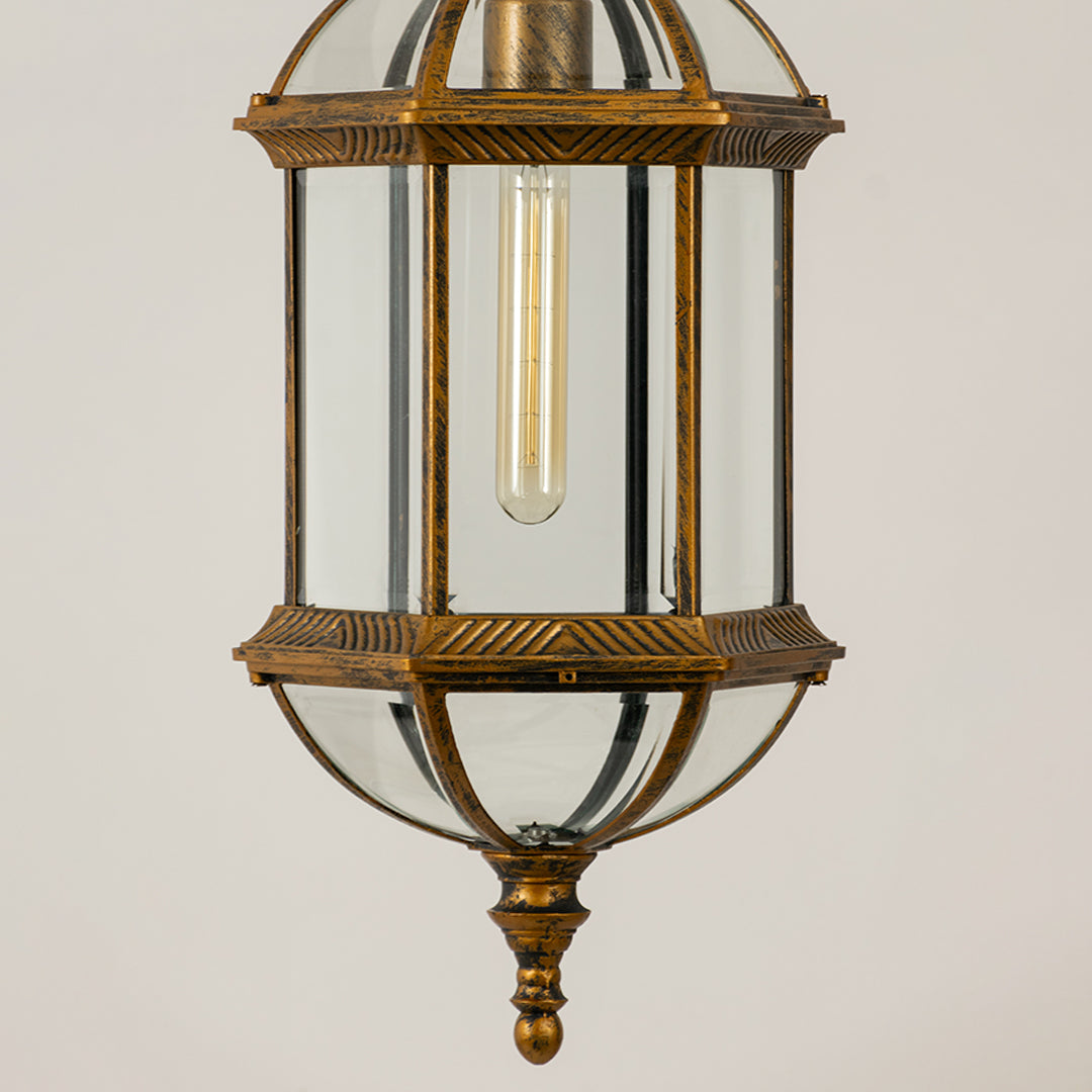Gold metal hanging outdoor lantern with glass enclosure glowing on white background suitable for porch entrance and exterior decor lighting.