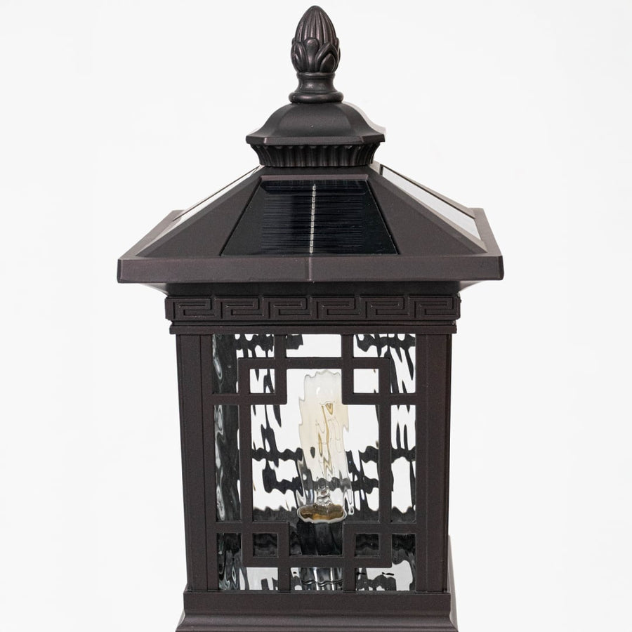 Closeup of solar outdoor lantern highlighting black metal cage design integrated solar panel and decorative exterior lighting style.