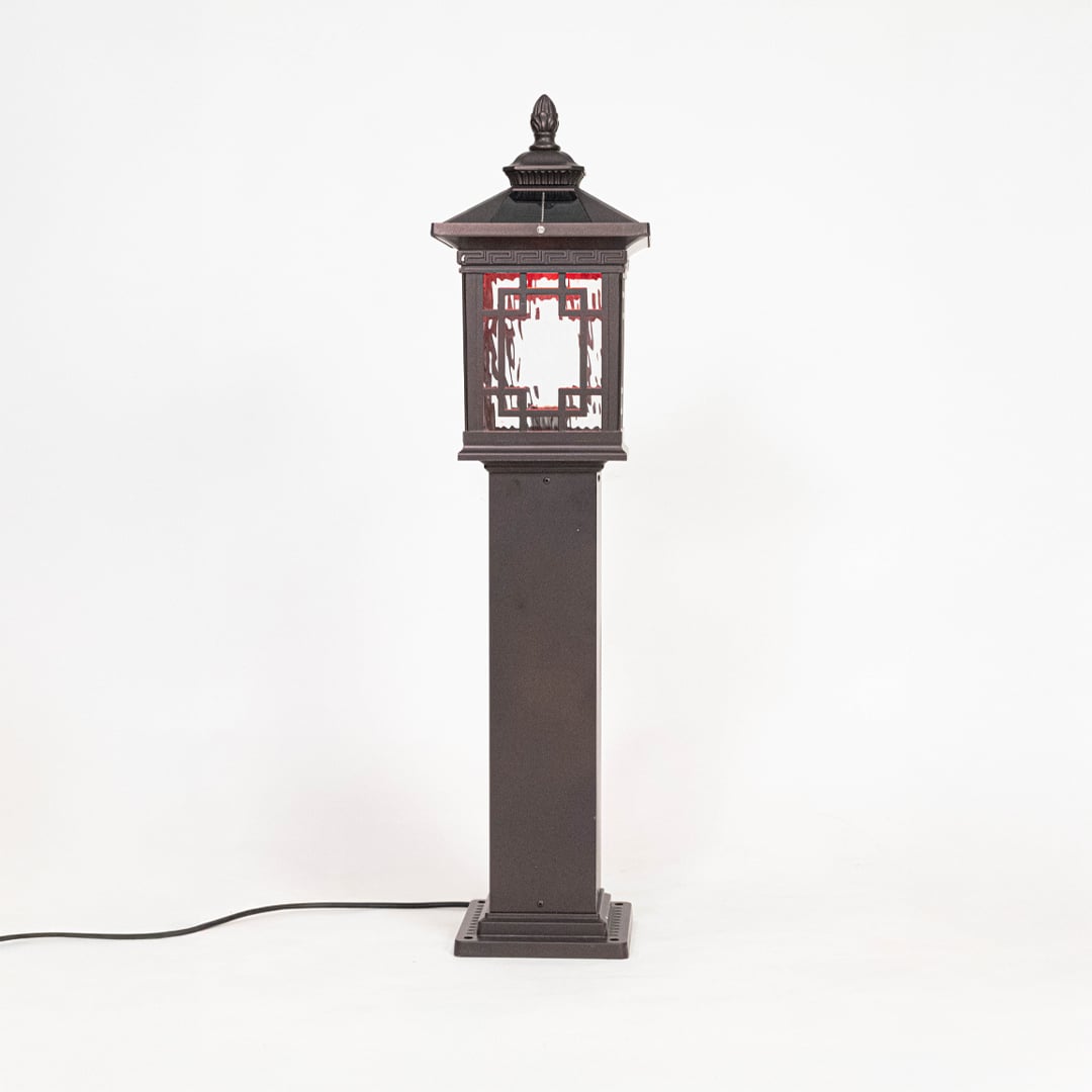 Classic black pillar lamp post glowing softly with frosted glass shade ideal for outdoor entrance lighting decor.
