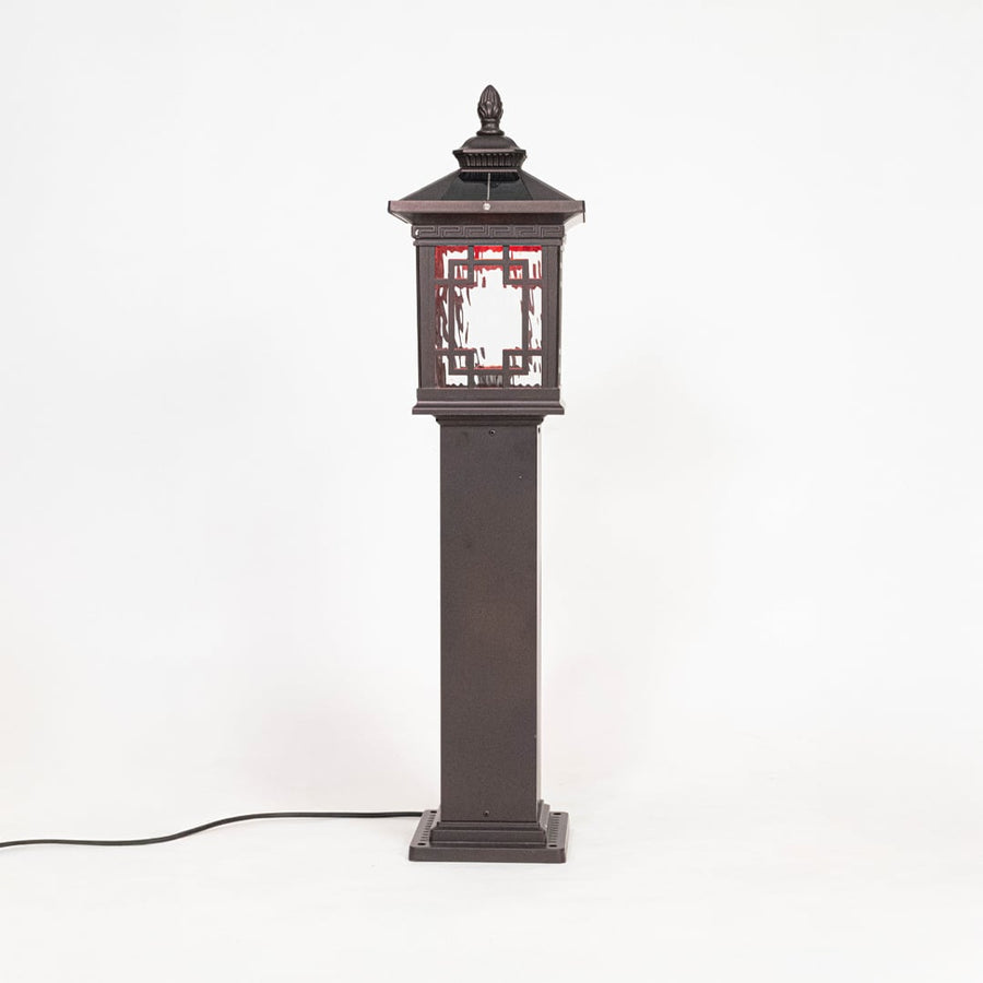 Classic black pillar lamp post glowing softly with frosted glass shade ideal for outdoor entrance lighting decor.