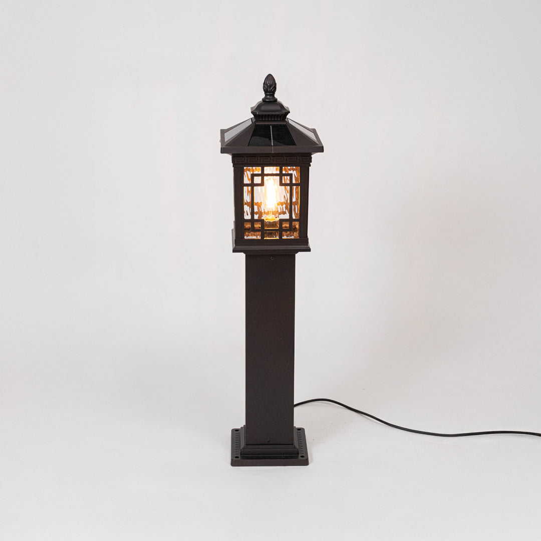 Vintage black outdoor gate light with warm glowing lattice panels for elegant exterior decor use.