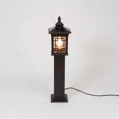 Vintage black outdoor gate light with warm glowing lattice panels for elegant exterior decor use.