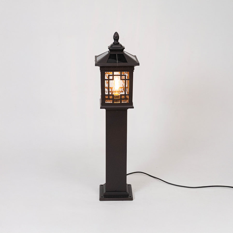 Vintage black outdoor gate light with warm glowing lattice panels for elegant exterior decor use.