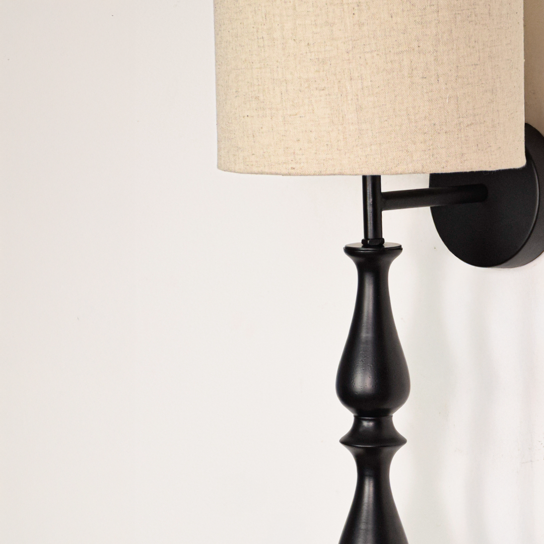 Lamp styled wall light closeup highlighting smooth black metal profile with textured fabric shade showcasing premium craftsmanship and elegant vertical design.