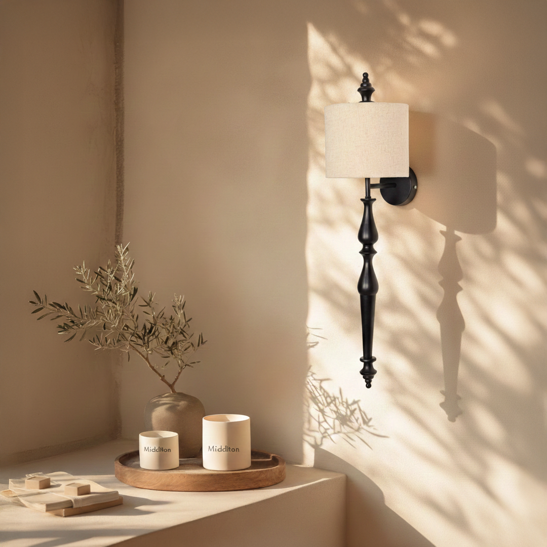 Lamp styled wall light glowing on beige wall above wooden console with black metal stem and fabric shade creating warm modern luxury Decor.
