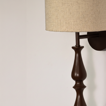 Lamp styled wall light closeup highlighting smooth black metal profile with textured fabric shade showcasing premium craftsmanship and elegant vertical form.