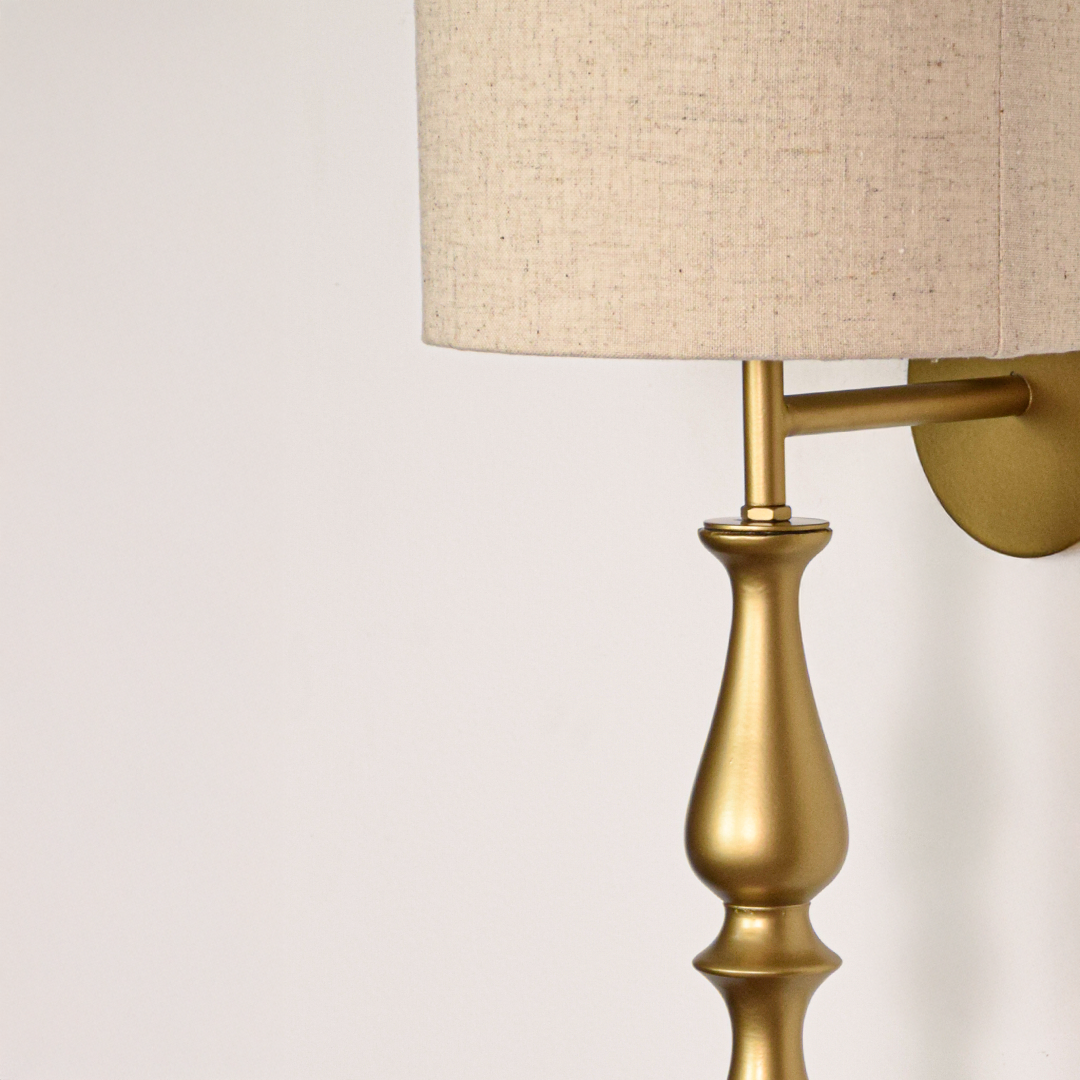 Lamp styled wall light closeup highlighting smooth gold metal profile with textured fabric shade showcasing premium craftsmanship and elegant vertical form.