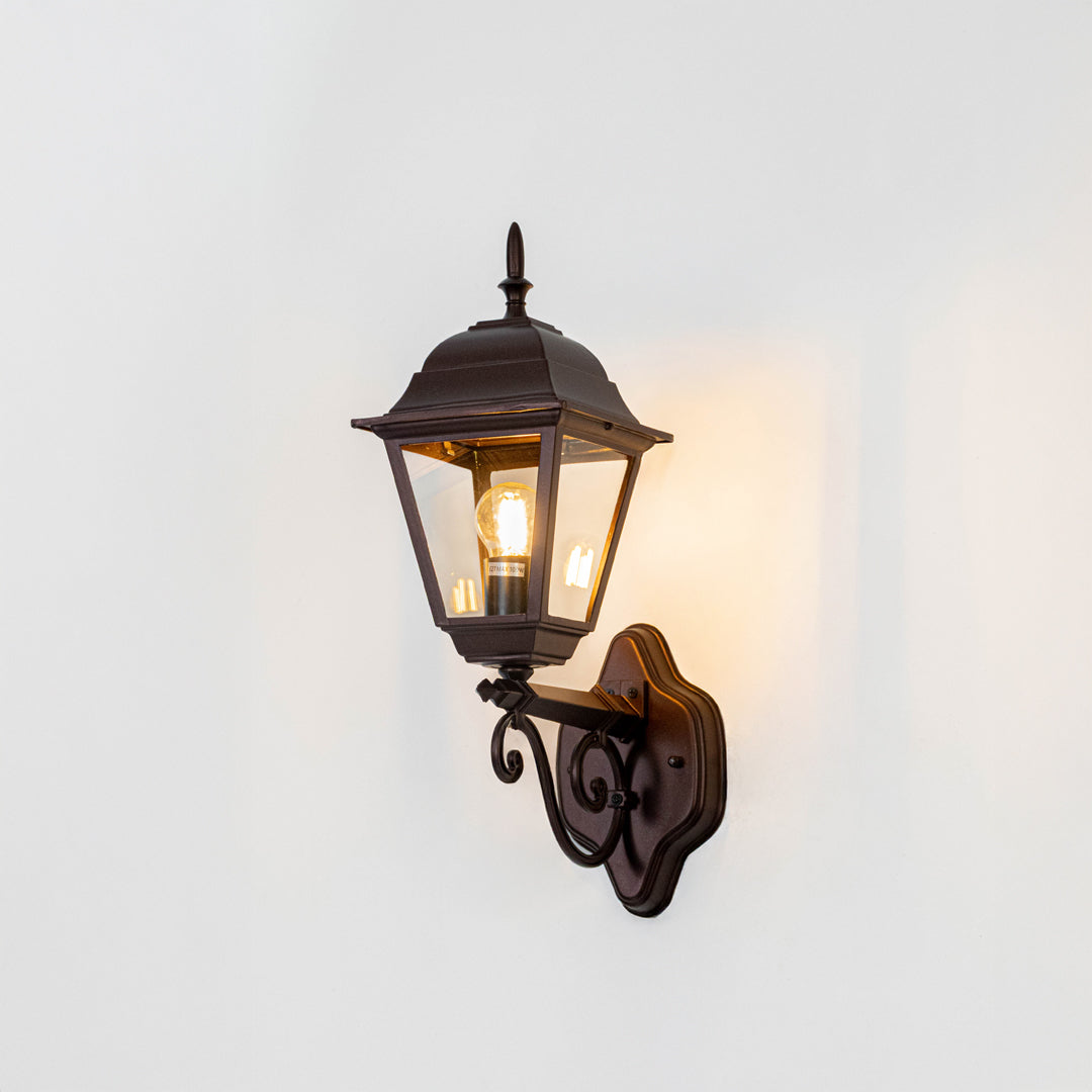 Vintage bronze outdoor lantern wall light on white background with decorative mount for classic exterior decor.