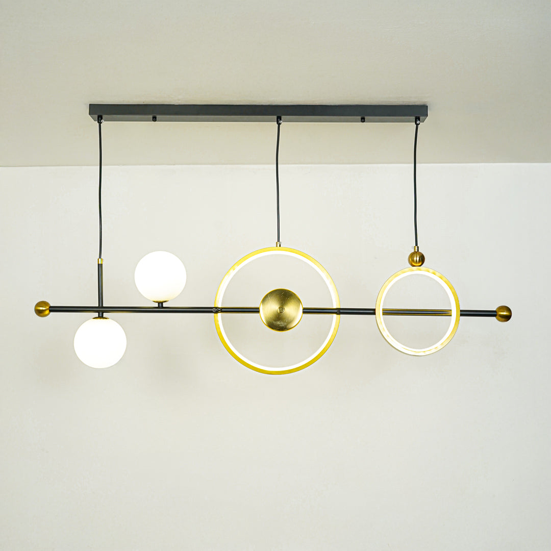 Modern linear pendant light with white glass globe and gold ring accents suspended on black rod against neutral wall background ideal for contemporary lighting.