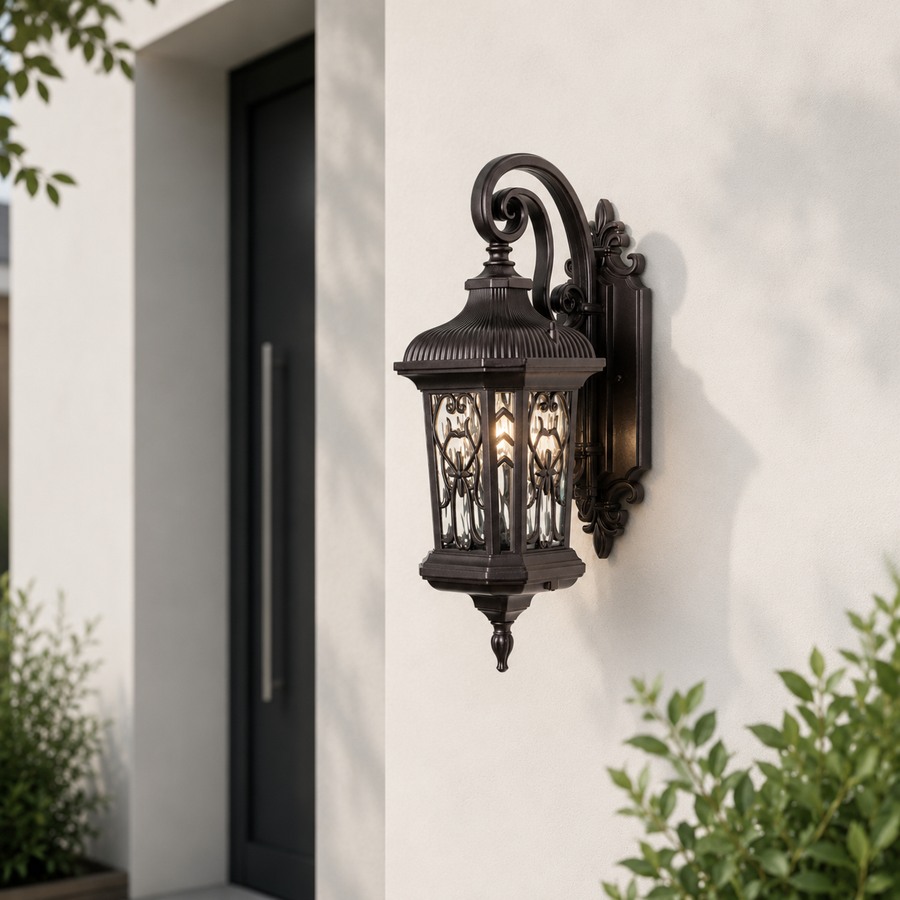 Classic black outdoor wall lantern with ornate metal detailing and clear glass panels installed beside a contemporary front door.