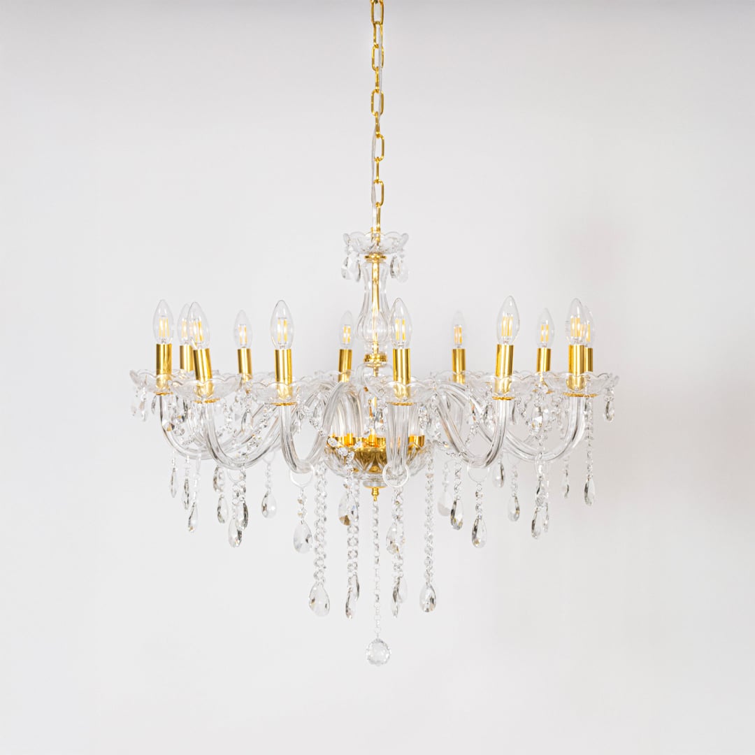 Classic chandelier with gold detailing and crystal droplets displayed off on white background for stylish lighting.