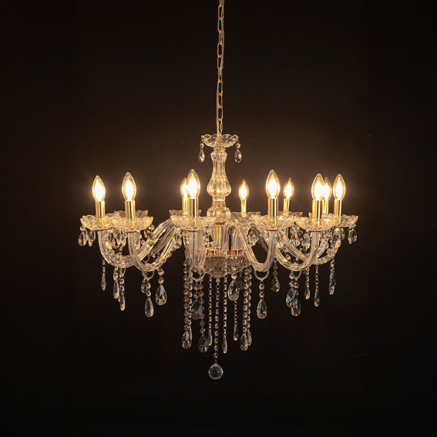 Elegant chandelier with crystal and gold detailing illuminated against black background for stylish luxury decor.