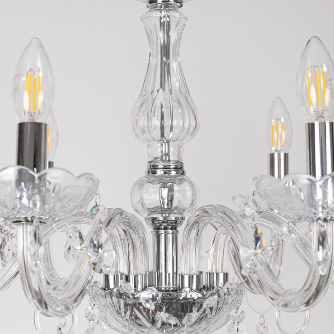 Closeup of crystal chandelier showing candle style bulbs glass detailing and crystal accents for luxury home decor.