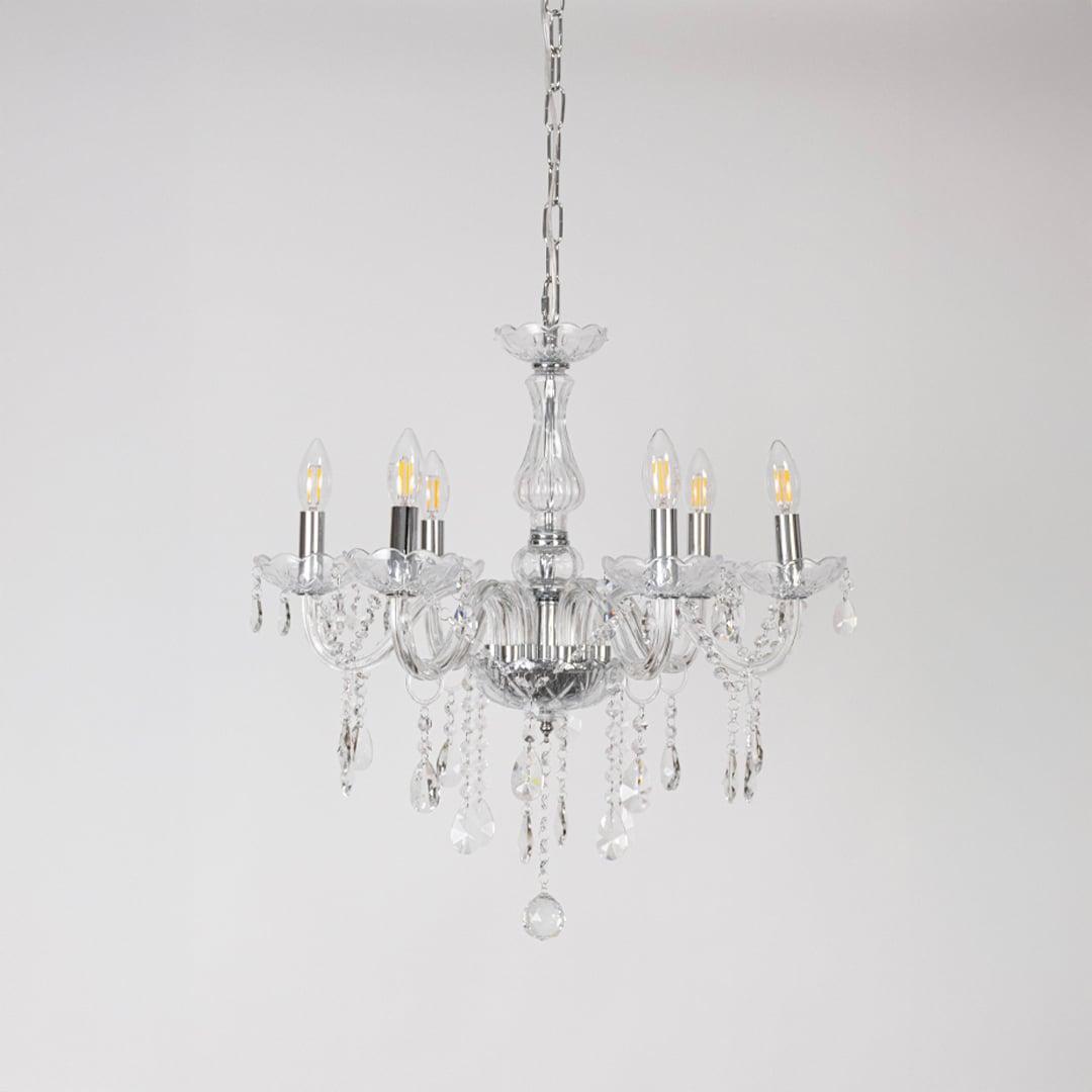 Crystal chandelier with lights off showing glass arms and crystal chains photographed on plain white background.