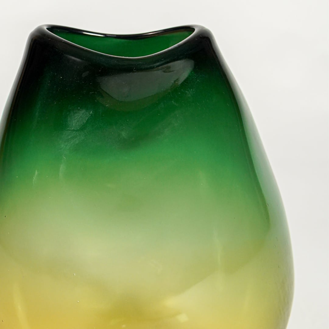 Close up view green amber gradient glass vase showing smooth glossy surface luxury decorative glass accent for shelf styling home.