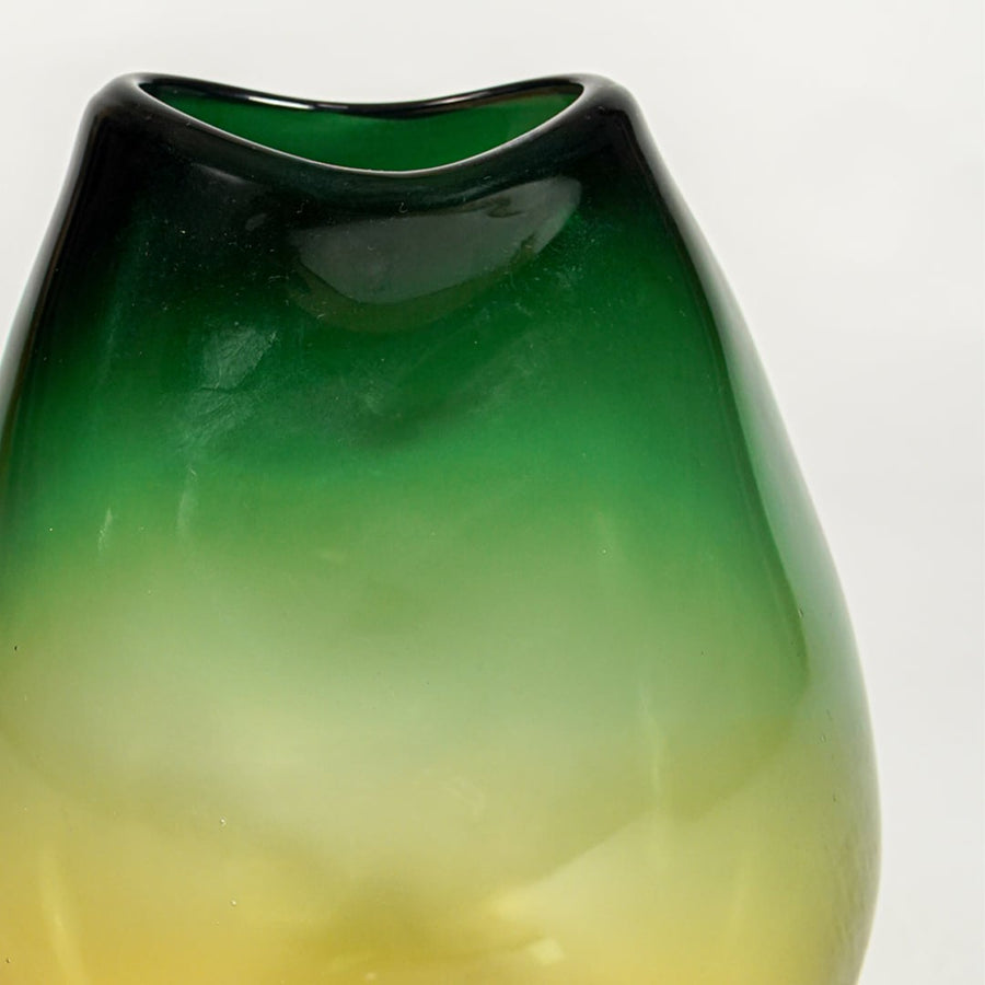 Close up view green amber gradient glass vase showing smooth glossy surface luxury decorative glass accent for shelf styling home.