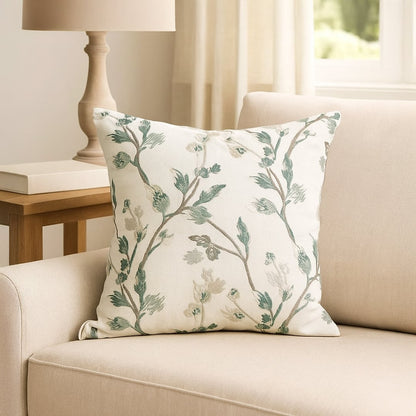 Soft cotton cushion cover with green botanical embroidery placed on a beige sofa enhancing home décor with a fresh natural style and a smooth comfortable skin friendly feel.