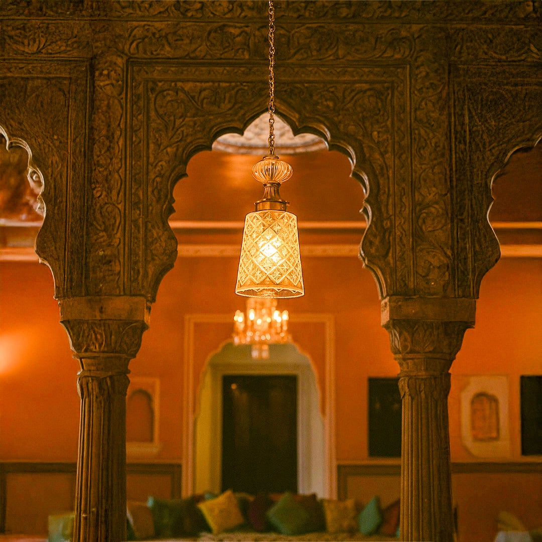 Green glass and gold metal pendant light creating warm ambience in luxurious heritage inspired interiors.