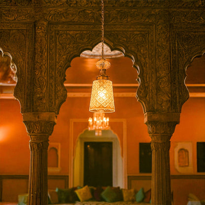 Green glass and gold metal pendant light creating warm ambience in luxurious heritage inspired interiors.