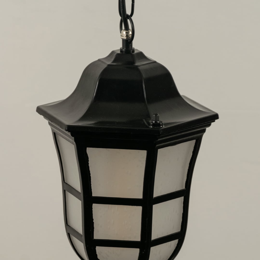 Close up view of the classic black metal lantern hanging light showing the grid detail on the frosted glass and the chain suspension.