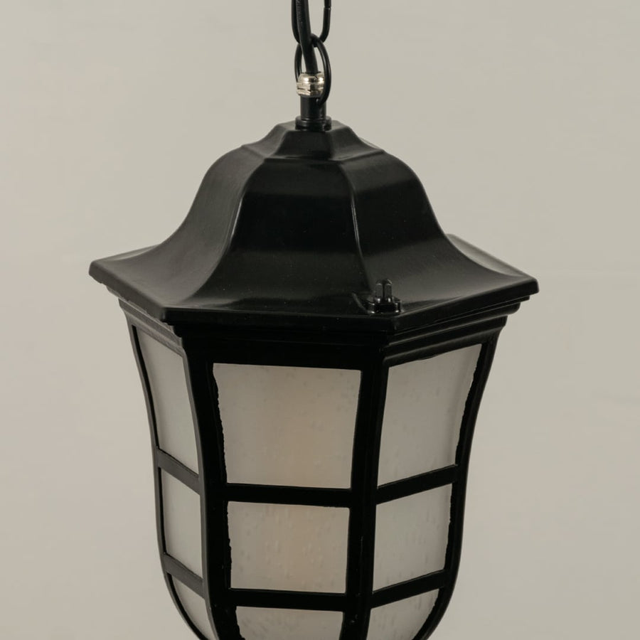 Close up view of the classic black metal lantern hanging light showing the grid detail on the frosted glass and the chain suspension.