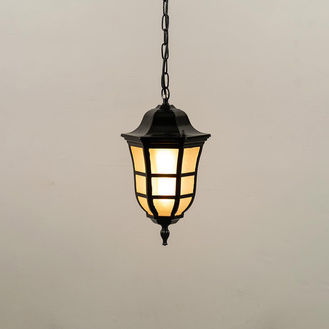 Black metal hanging outdoor lantern with glass panels glowing on white background ideal for gate entrance and exterior lighting decor.