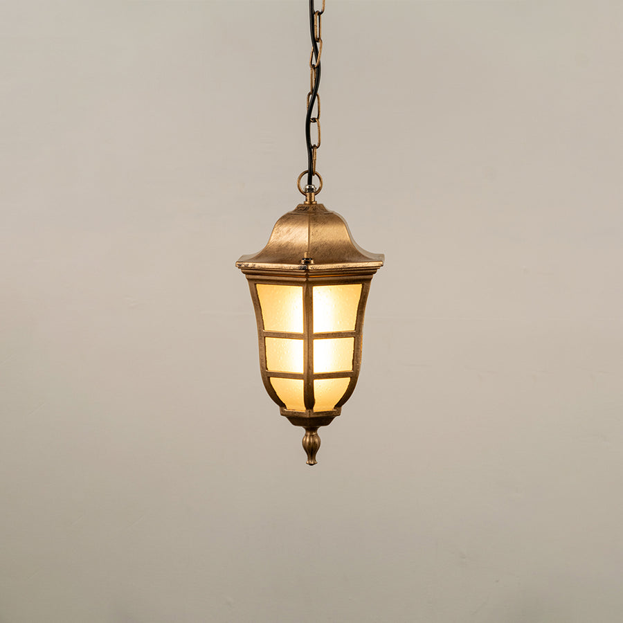 Gold metal hanging outdoor lantern with cylindrical glass design glowing on white background suitable for porch entrance and exterior decor lighting.